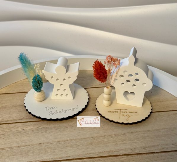 Dekoteller beleuchtet Dekorative Tischaufsteller in Form von Engel und Haus mit bunten Trockenblumen.